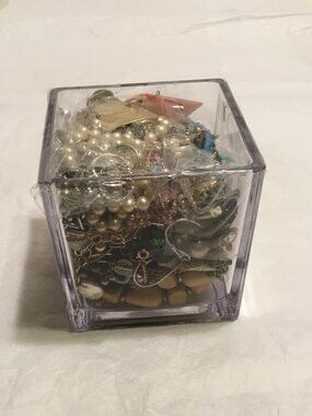 Heavy glass vase filled with old, used broken jewelry